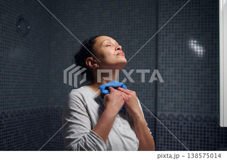 Middle-Aged Woman in Pajamas Doing Morning Facial Care During Daily Hygiene Routine Middle-Aged Woman in Pajamas Doing Morning Facial Care During Daily Hygiene Routine 138575014