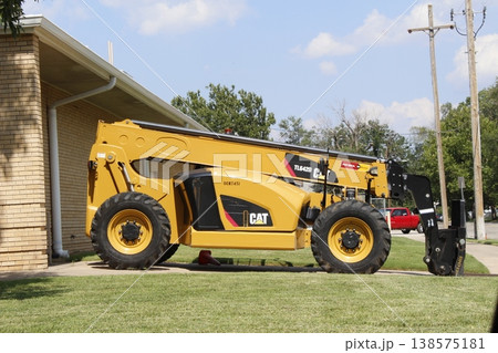 A Cat Telehandler parked in a driveway with blue sky 138575181