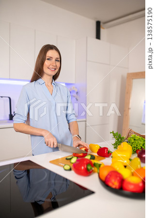 Young vegetarian woman in the kitchen feeling enjoyed while preparing food Young vegetarian woman in the kitchen feeling enjoyed while preparing food 138575190