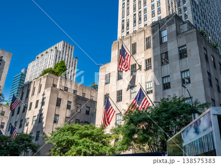 New york, usa august 14,2024. American flags drape rockefeller center facades under a clear blue manhattan sky, symbolizing pride and iconic new york architecture New york, usa august 14,2024. American flags drape rockefeller center facades under a clear blue manhattan sky, symbolizing pride and iconic new york architecture 138575383