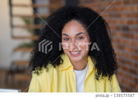 Pretty young long-haired woman in yellow jacket working from home 138575587