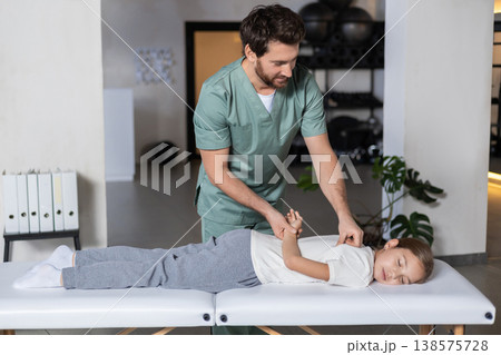 Specialist assisting girl with back rehabilitation exercises Specialist assisting girl with back rehabilitation exercises 138575728