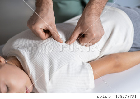 Close up of therapist hands massaging child shoulders 138575731