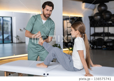 Specialist massaging child foot for recovery in clinic 138575741