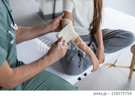 Detail of elastic bandage being applied to girl arm 138575758