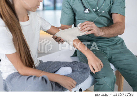 Close up of doctor hands wrapping child elbow Close up of doctor hands wrapping child elbow 138575759