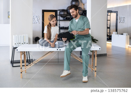 Male doctor talking to young girl during consultation 138575762