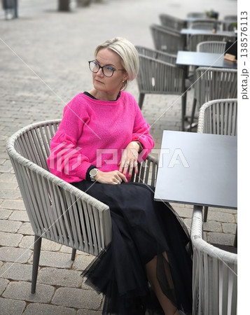Stylish woman in street cafe. Fashionable blonde relaxes on cafe terrace Stylish woman in street cafe. Fashionable blonde relaxes on cafe terrace 138576113