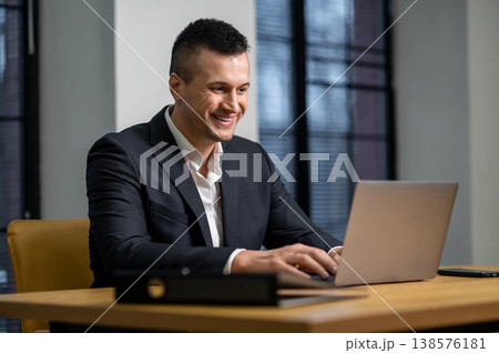 Corporate male professional managing work tasks on laptop in workplace 138576181