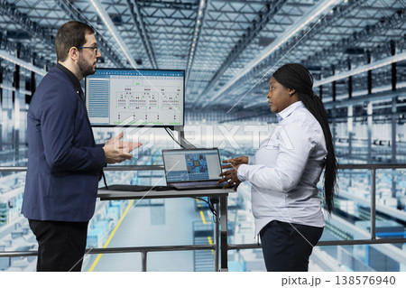 Businesspeople visualizing microchip factory conveyor belts bottlenecks on dashboard. Teamworking colleagues looking at data on display, improving semiconductors fabrication supply chain yield Businesspeople visualizing microchip factory conveyor belts bottlenecks on dashboard. Teamworking colleagues looking at data on display, improving semiconductors fabrication supply chain yield 138576940