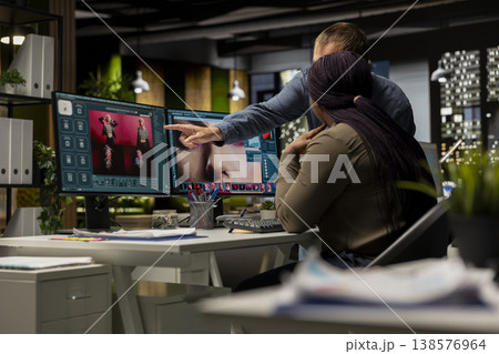 Diverse photo editing team generating AI content and retouching pictures, working on their creative portfolio with text to image program and futuristic software. Advanced editors. 138576964