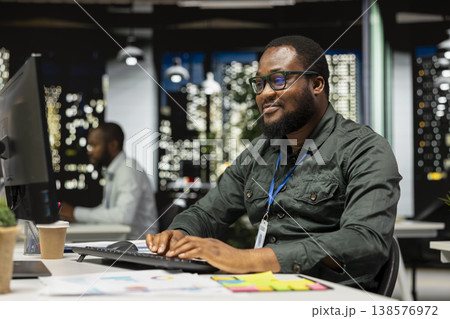 Black male advisor documenting numbers and finance metrics after hours, researching updates and organizing the agenda for business management. Guy setting targets and objectives. 138576972