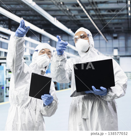 Multiethnic engineering team working together in microelectronics production factory, overseeing infrastructure. Microchips plant teamworking colleagues tracking PCB fabrication lots with devices Multiethnic engineering team working together in microelectronics production factory, overseeing infrastructure. Microchips plant teamworking colleagues tracking PCB fabrication lots with devices 138577032