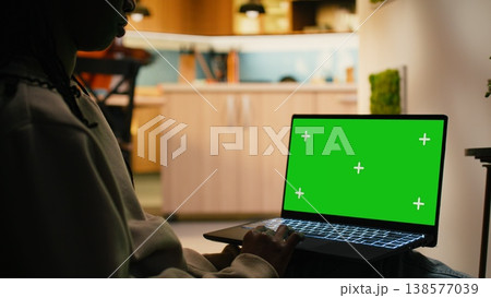Chroma key on laptop with black female relaxing in hallway at home, focused on warm daylight and cozy ambience indoor. Calm interior shows modern lifestyle and peaceful everyday living. 138577039
