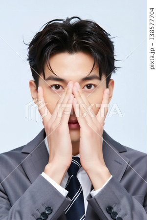 無表情で顔を隠すビジネスマン 無表情で顔を隠すビジネスマン 138577704