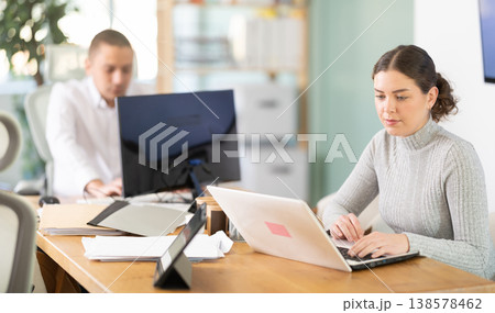 Young woman working on laptop in modern office Young woman working on laptop in modern office 138578462