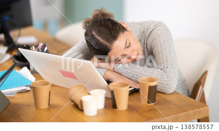 Tired young woman working on laptop 138578557