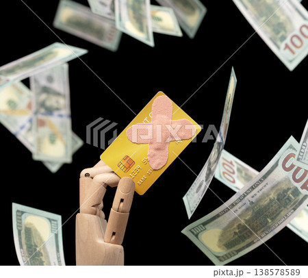 Mounting credit card debt, band-aid on card is deeper finance problem. Flying dollar bills represent uncontrolled spending. Band-aid solution can't fix stress of potential bankruptcy 138578589
