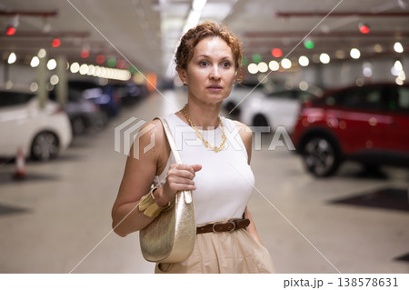 Adult woman standing in parking lot Adult woman standing in parking lot 138578631
