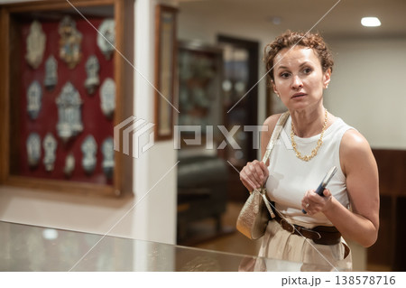 Thoughtful woman examining historacal exhibits in museum 138578716