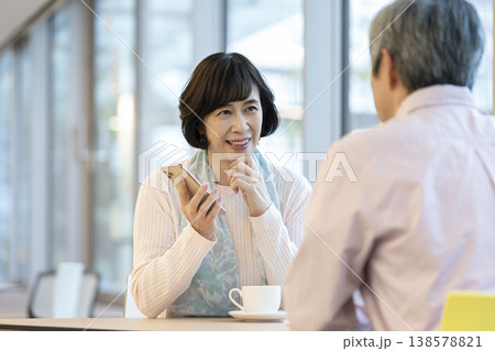 カフェでスマートフォンを持って話をするアラカンの女性 138578821