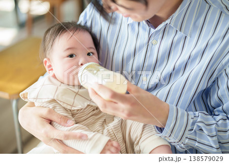 赤ちゃんにミルクを与えるお父さん 赤ちゃんにミルクを与えるお父さん 138579029