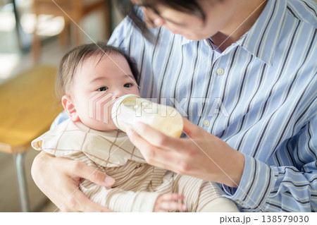 赤ちゃんにミルクを与えるお父さん 赤ちゃんにミルクを与えるお父さん 138579030