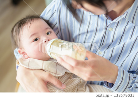 赤ちゃんにミルクを与えるお父さん 赤ちゃんにミルクを与えるお父さん 138579033