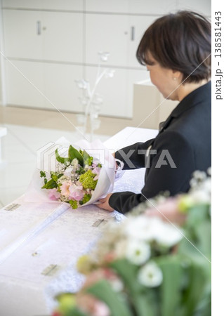 やさしく供花を置く葬儀スタッフの手元 138581443
