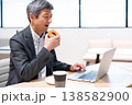 オフィスでドーナツを食べて休憩するミドル層のビジネスマン オフィスでドーナツを食べて休憩するミドル層のビジネスマン 138582900