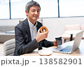 オフィスでドーナツを食べて休憩するミドル層のビジネスマン オフィスでドーナツを食べて休憩するミドル層のビジネスマン 138582901