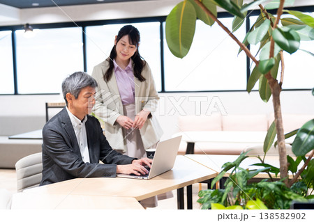 仕事の相談やアドバイスを行う男女のビジネスマン 仕事の相談やアドバイスを行う男女のビジネスマン 138582902