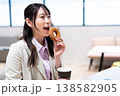 仕事の合間にコーヒーとドーナツでリラックスする女性 仕事の合間にコーヒーとドーナツでリラックスする女性 138582905