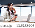 仕事の合間にコーヒーとドーナツでリラックスする女性 仕事の合間にコーヒーとドーナツでリラックスする女性 138582906
