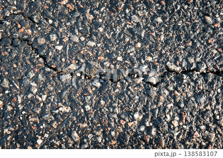 Cracked Asphalt Pavement Surface Showing Weather Damage And Salt Exposure 138583107