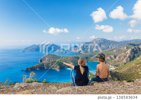 Little kids looking at beautiful view Oludeniz beach, Lycia coast. Summer day walk by Lycian way at family vacation in Mediterranean Sea, Fethye, Antalya region, Turkey Little kids looking at beautiful view Oludeniz beach, Lycia coast. Summer day walk by Lycian way at family vacation in Mediterranean Sea, Fethye, Antalya region, Turkey 138583634
