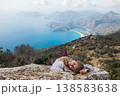 Young woman lying on high cliff over Oludeniz beach, Lycia coast. Summer day walk by Lycian way at family vacation in Mediterranean Sea, Fethye, Antalya region, Turkey 138583638
