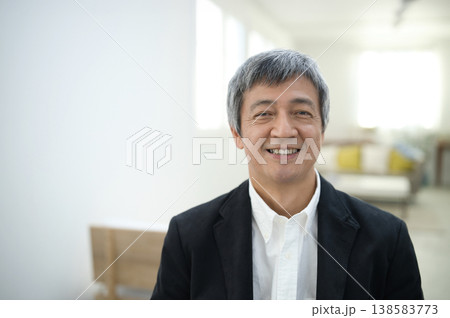 部屋でジャケットを着て微笑む60代の男性 部屋でジャケットを着て微笑む60代の男性 138583773