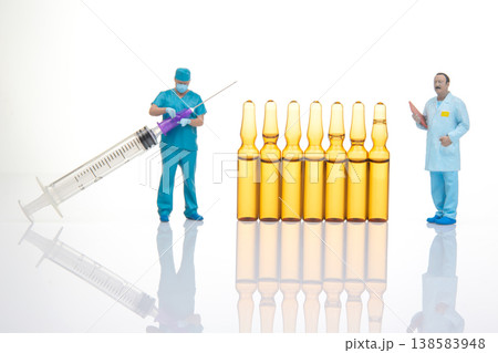 Miniature people with a syringe and vials in a clean setting during a health-related activity Miniature people with a syringe and vials in a clean setting during a health-related activity 138583948