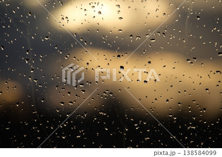 Raindrops on Window With Golden Sunset Bokeh Reflections Over Out-Of-Focus Cityscape Raindrops on Window With Golden Sunset Bokeh Reflections Over Out-Of-Focus Cityscape 138584099