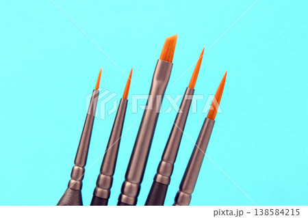 Different sizes of paint brushes on a blue background ready for art projects and creative activities 138584215