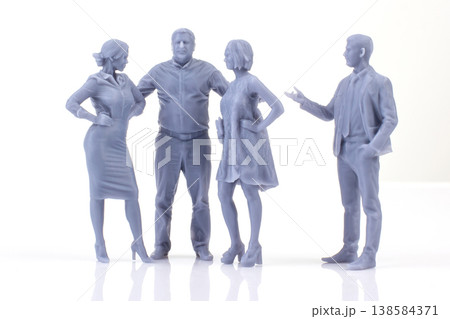 Miniature people stand in group while discussing their plans for the day in a simple indoor setting 138584371