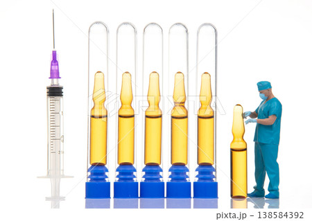 Miniature figures interact with lab equipment and syringes in a science setting during daylight 138584392