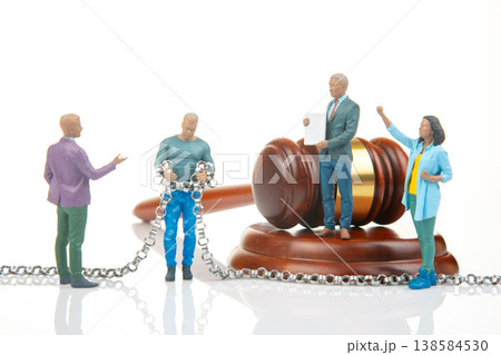 Miniature figurines interact in courtroom scene discussing justice and freedom with a judge present Miniature figurines interact in courtroom scene discussing justice and freedom with a judge present 138584530