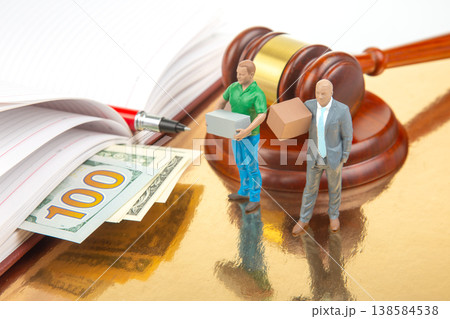 Miniature people stand by gavel and money while holding boxes in a legal setting involving commerce Miniature people stand by gavel and money while holding boxes in a legal setting involving commerce 138584538