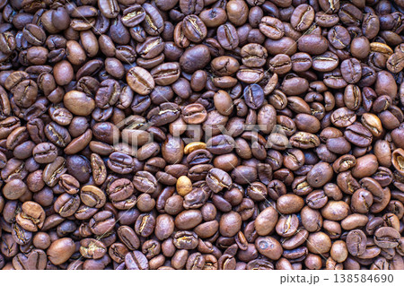 Large collection of brown coffee beans spread on a flat surface for roasting and grinding in a home Large collection of brown coffee beans spread on a flat surface for roasting and grinding in a home 138584690