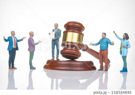 Miniature people gather around gavel in court scene showing legal proceedings and discussions Miniature people gather around gavel in court scene showing legal proceedings and discussions 138584695