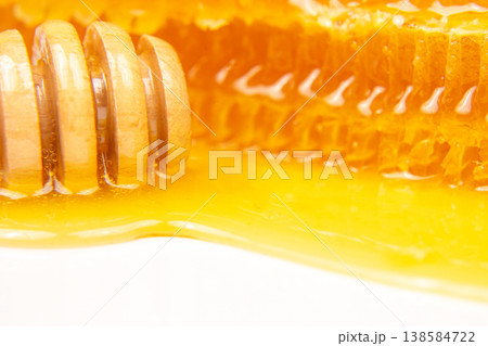 Honey drips from a honeycomb in a close-up shot showing the natural sweetness and sticky texture Honey drips from a honeycomb in a close-up shot showing the natural sweetness and sticky texture 138584722