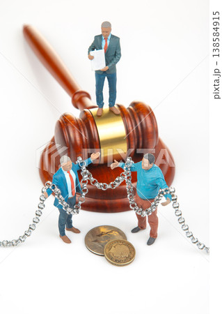 Miniature people are in front of a gavel Miniature people are in front of a gavel 138584915