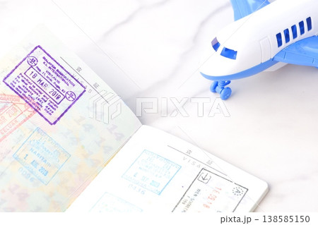 日本のパスポートを開いたビザのページと、飛行機で、長期休暇に海外旅行を計画しているイメージ 日本のパスポートを開いたビザのページと、飛行機で、長期休暇に海外旅行を計画しているイメージ 138585150